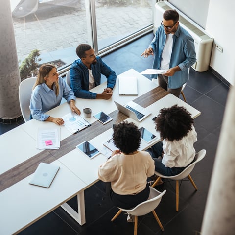 A diverse group of professionals in a modern office collaborating in a business meeting